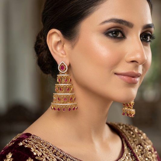 Woman wearing gold and red earrings with a blurred background