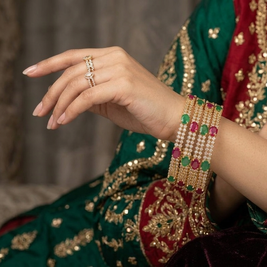 Close-up of hands wearing jewelry with a traditional embroidered garment in the background